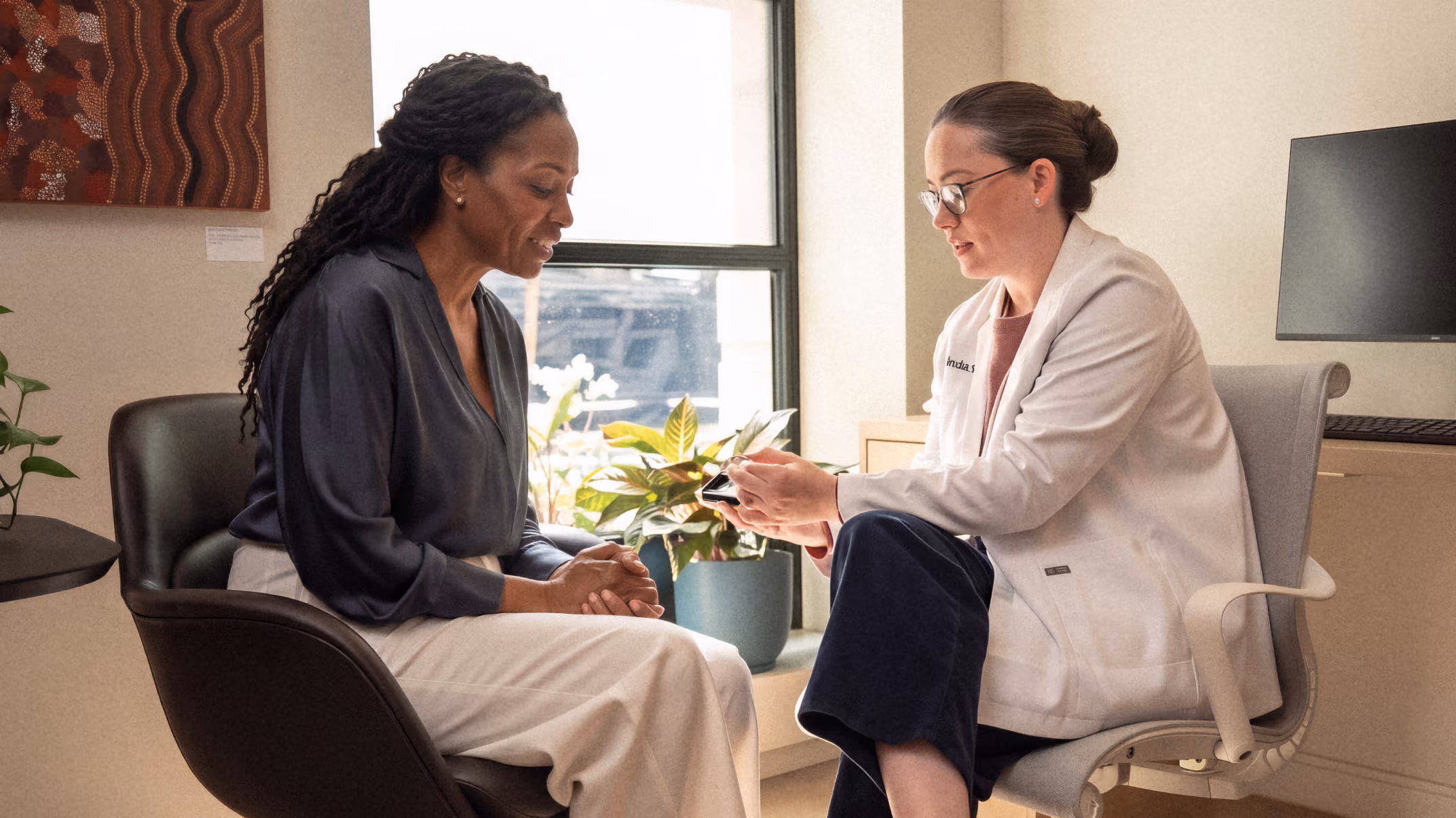 Fortell audiologist reviewing a phone screen with a patient during an appointment.