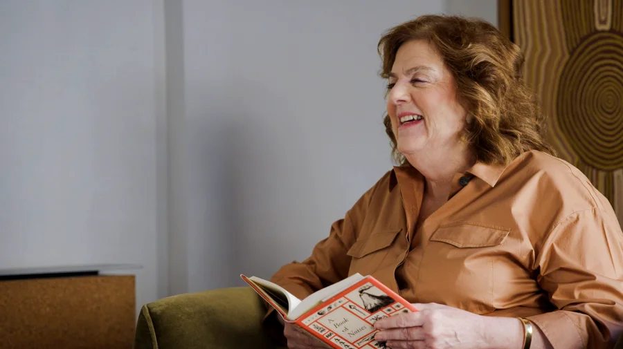Libby smiling while reading a book