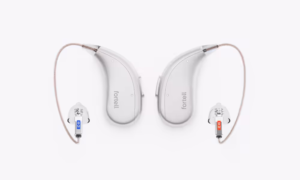 Pair of Silver Fortell hearing aids with clear wires and left and right ear tips.