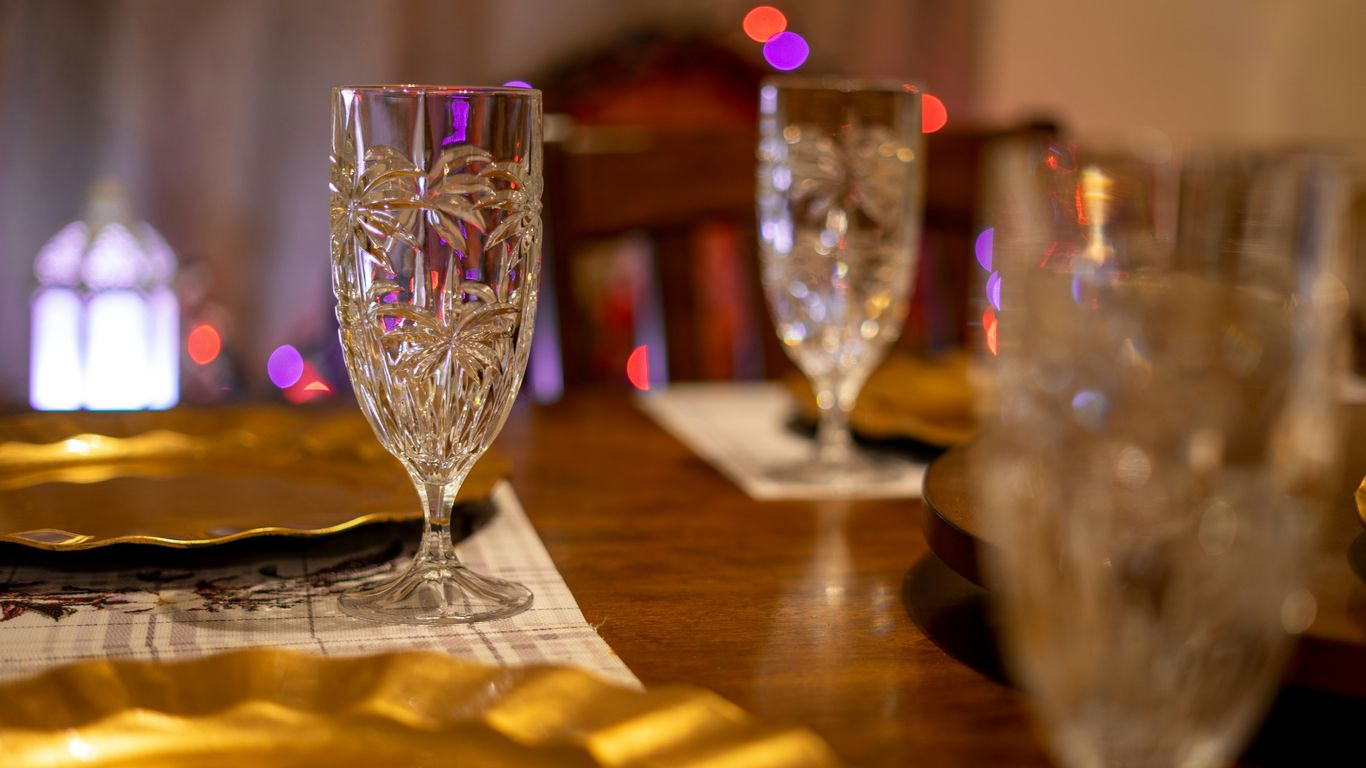 a wooden table topped with glasses and plates