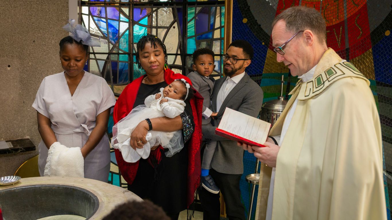 a priest holding a baby in a church