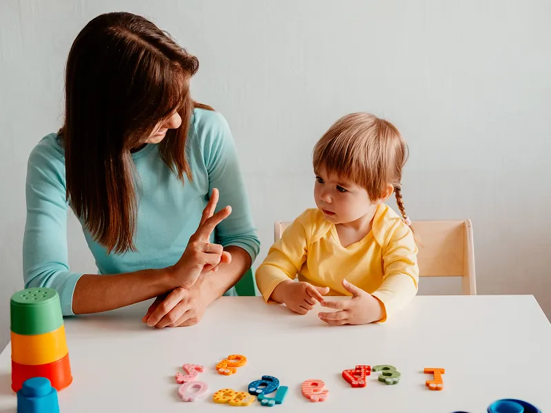 Child engaged in a speech therapy session in a calm and supportive therapy room.