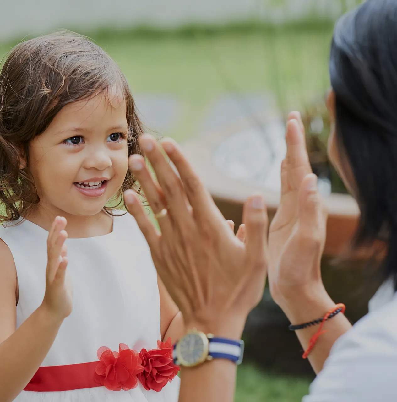 Mother supporting her young child showing signs of delayed speech and language development during a therapy session.