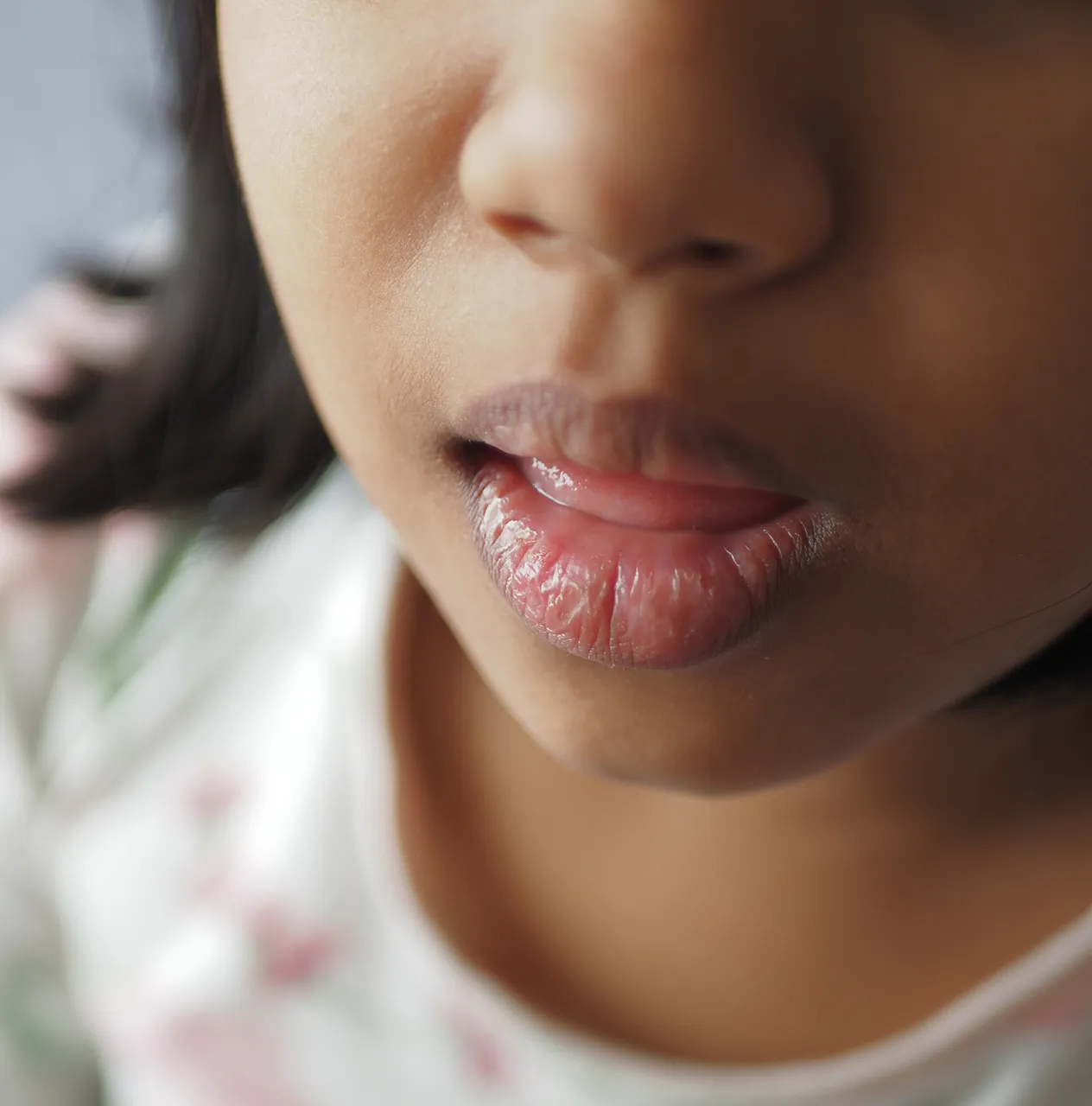Mother supporting her young child showing signs of delayed speech and language development during a therapy session.