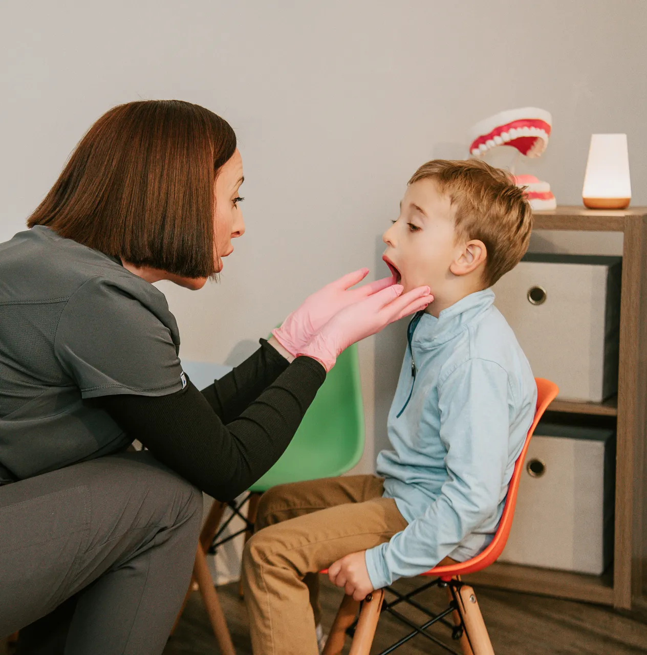 Mother helping her son who is struggling to understand and follow directions, illustrating a common speech and language challenge.