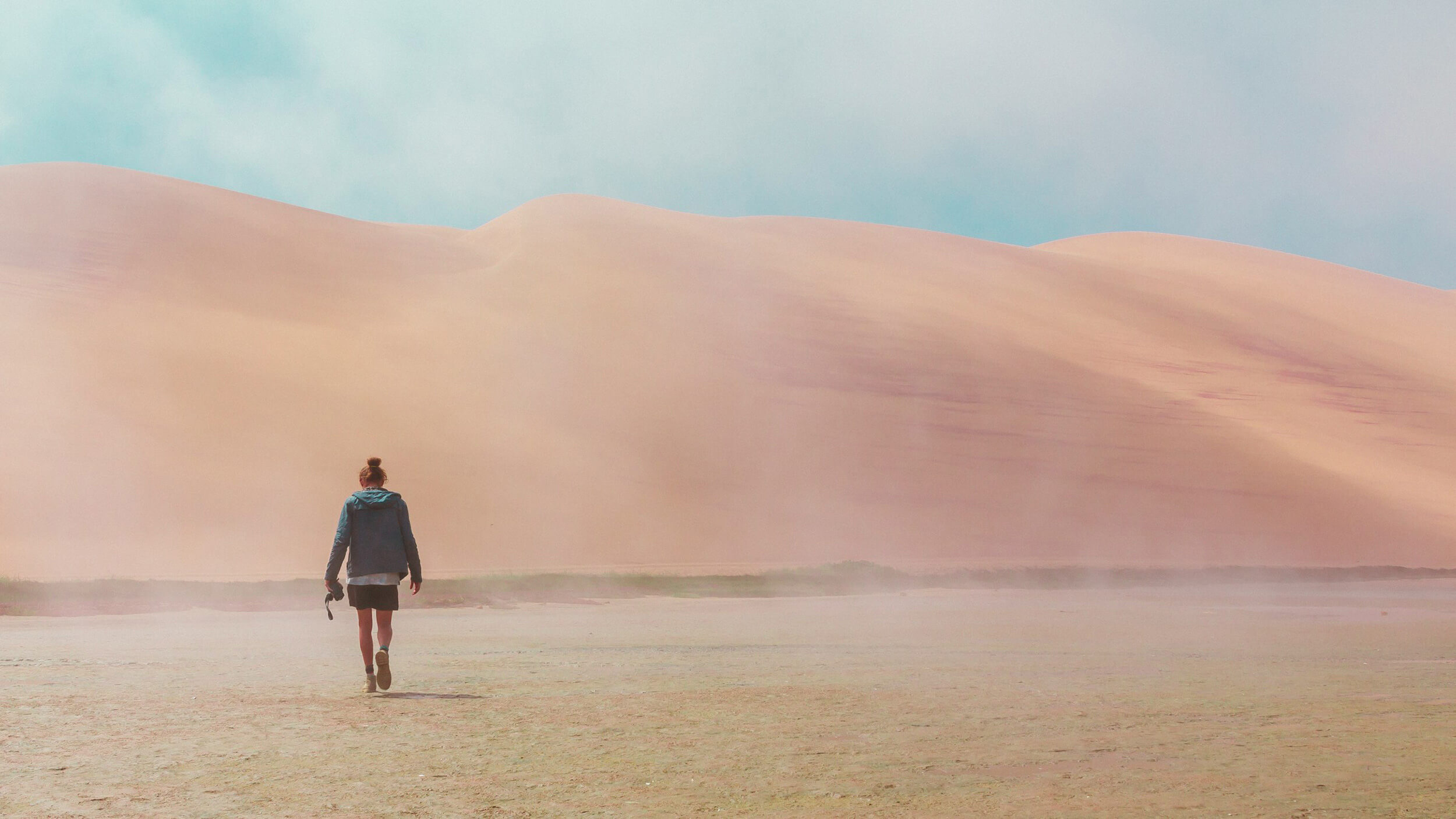 Woman walking through the sandy desert