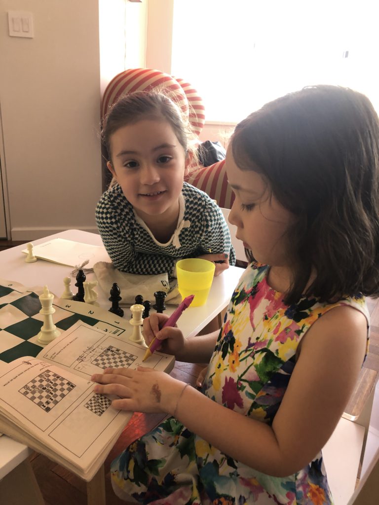 Kids doing a chess puzzle