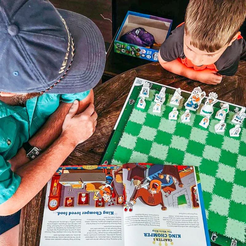 Interactive chess storytelling session with a book and custom chess pieces
