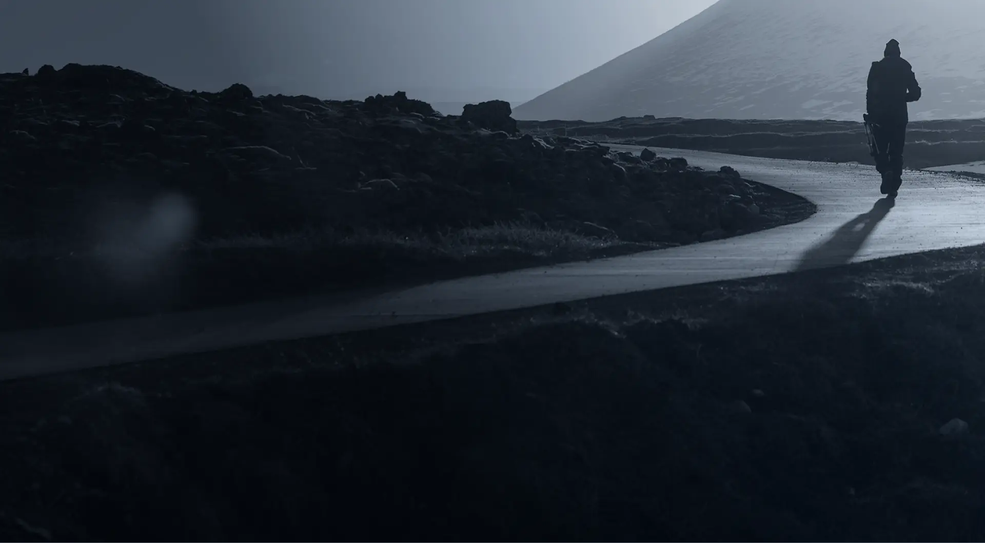 person walking along road in rugged terrain