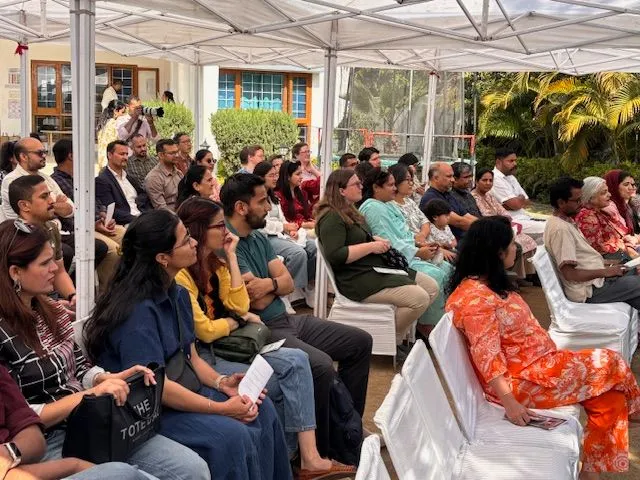 group of people sitting in chairs listening