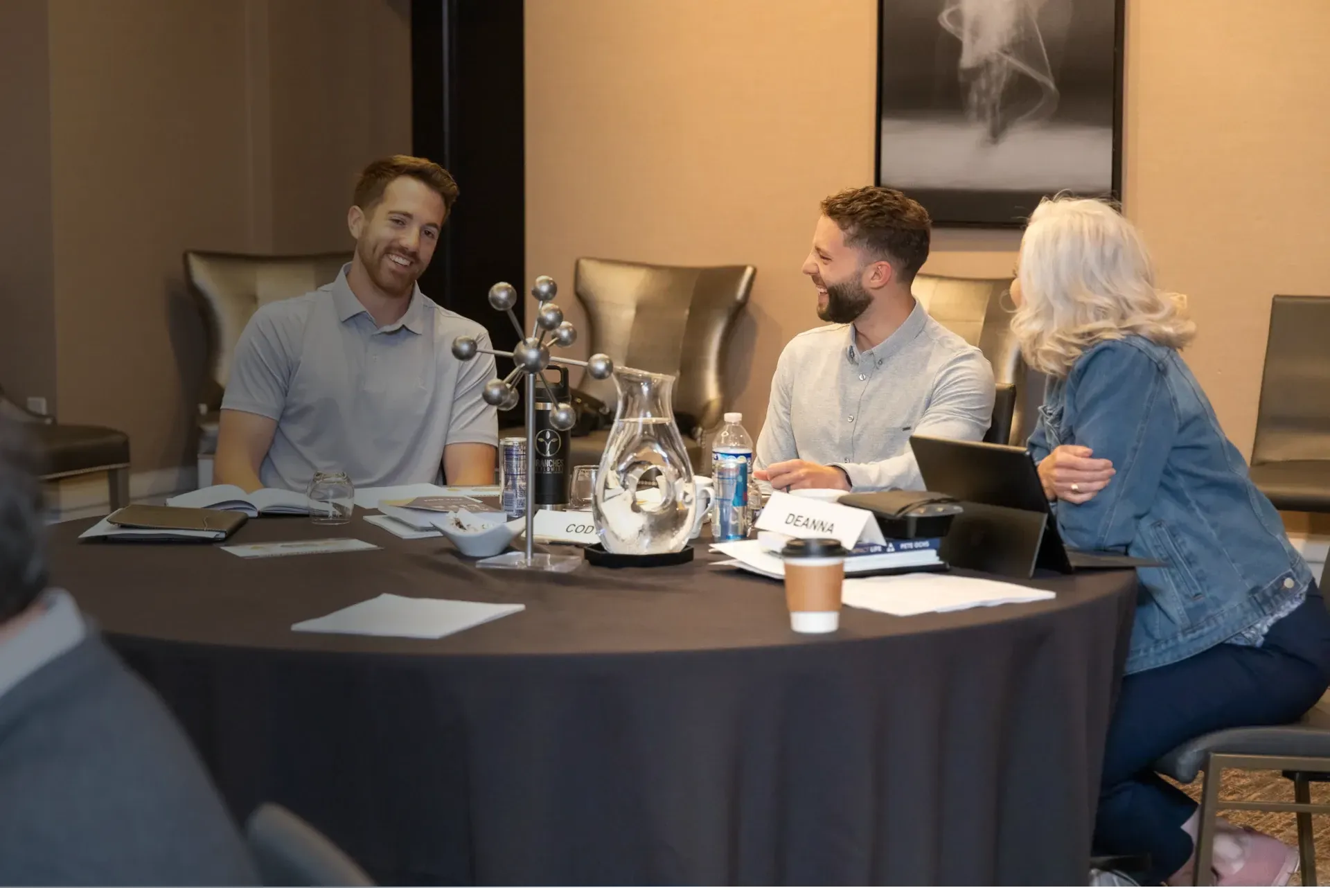group sitting at table togehter talking and laughing