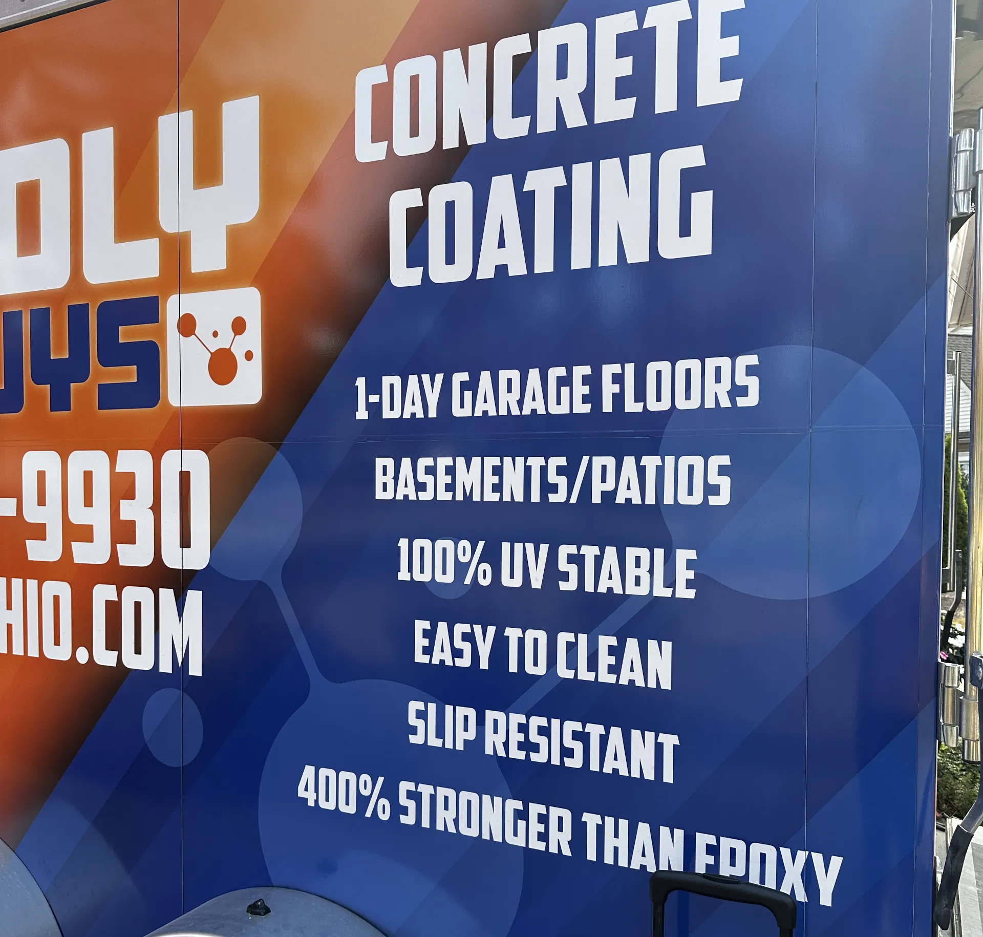 close up of a list of Poly Guys services on the side of a orange and blue trailer