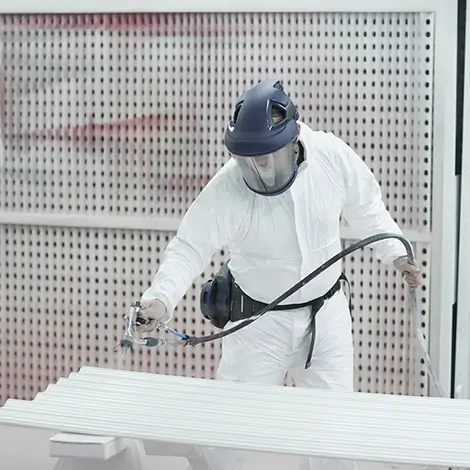 Person spray-painting joinery in a finishing booth