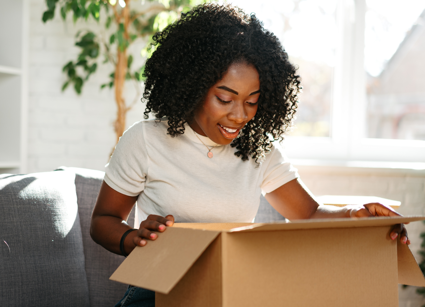 A woman opening a box that was delivered to her home 