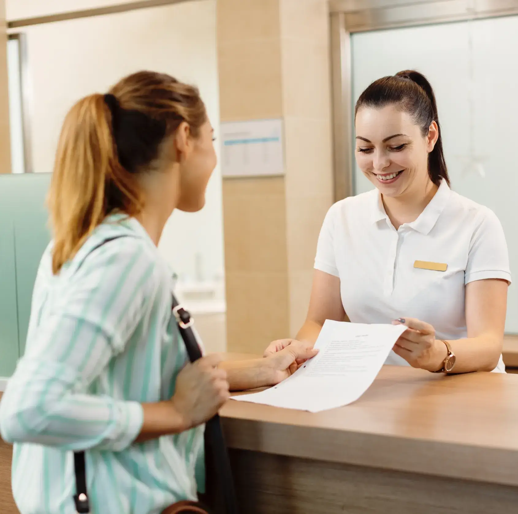 Staff handing a document to patient