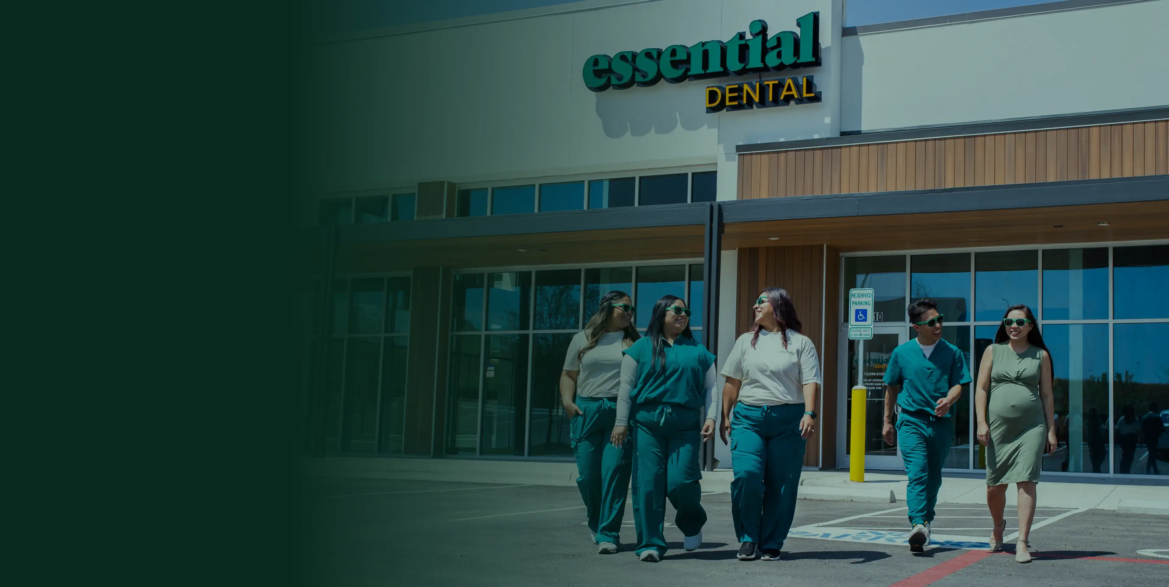 Five people in green scrubs walk in front of a dental clinic.