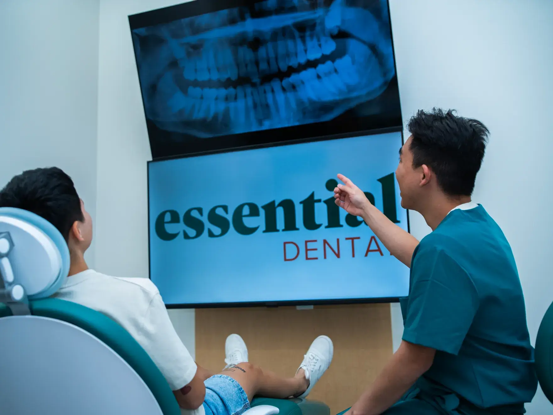 A dentist shows a dental X-ray to a patient in a clinic.