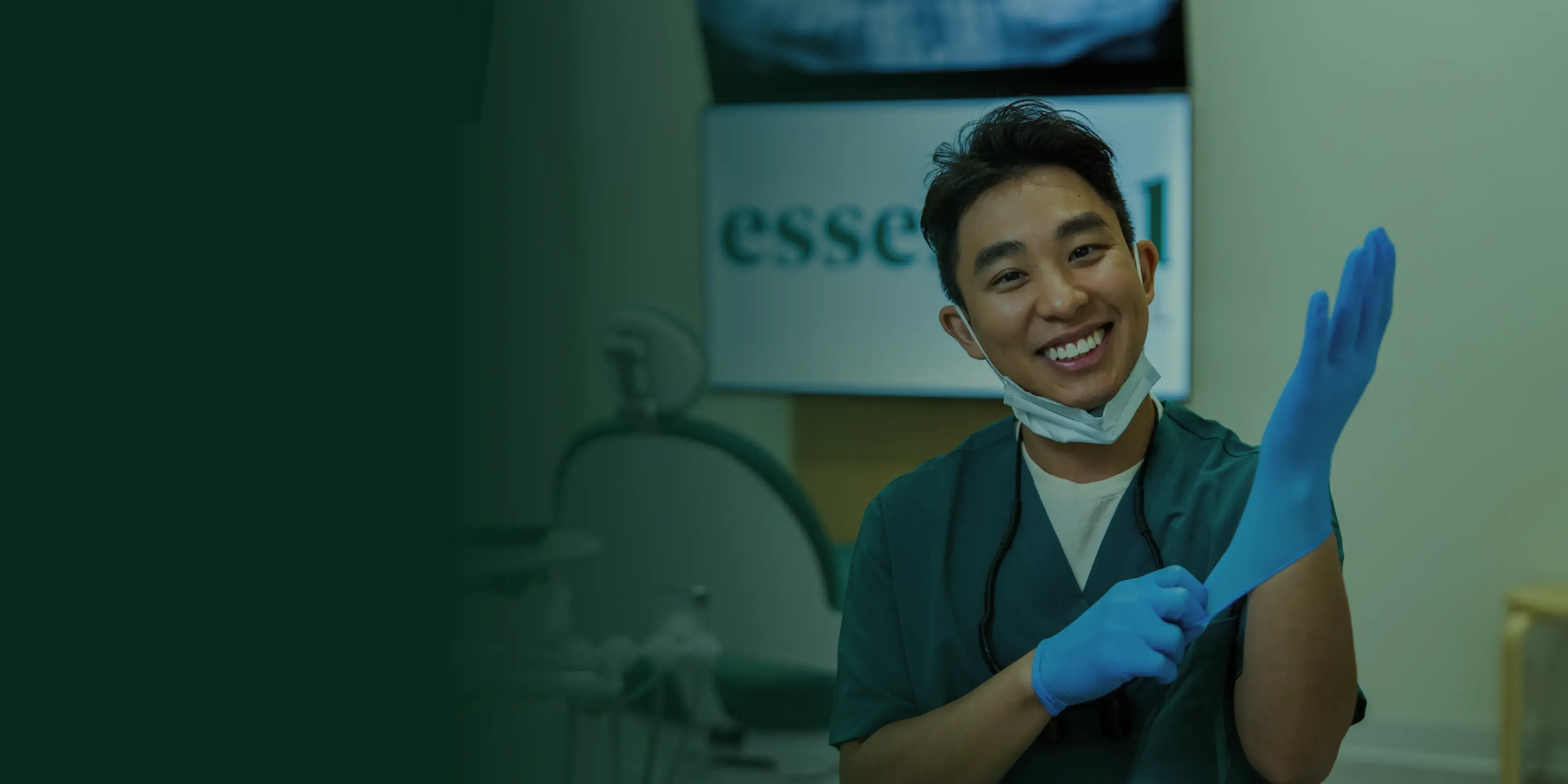 Smiling dentist wearing gloves in a dental office, preparing for a procedure.