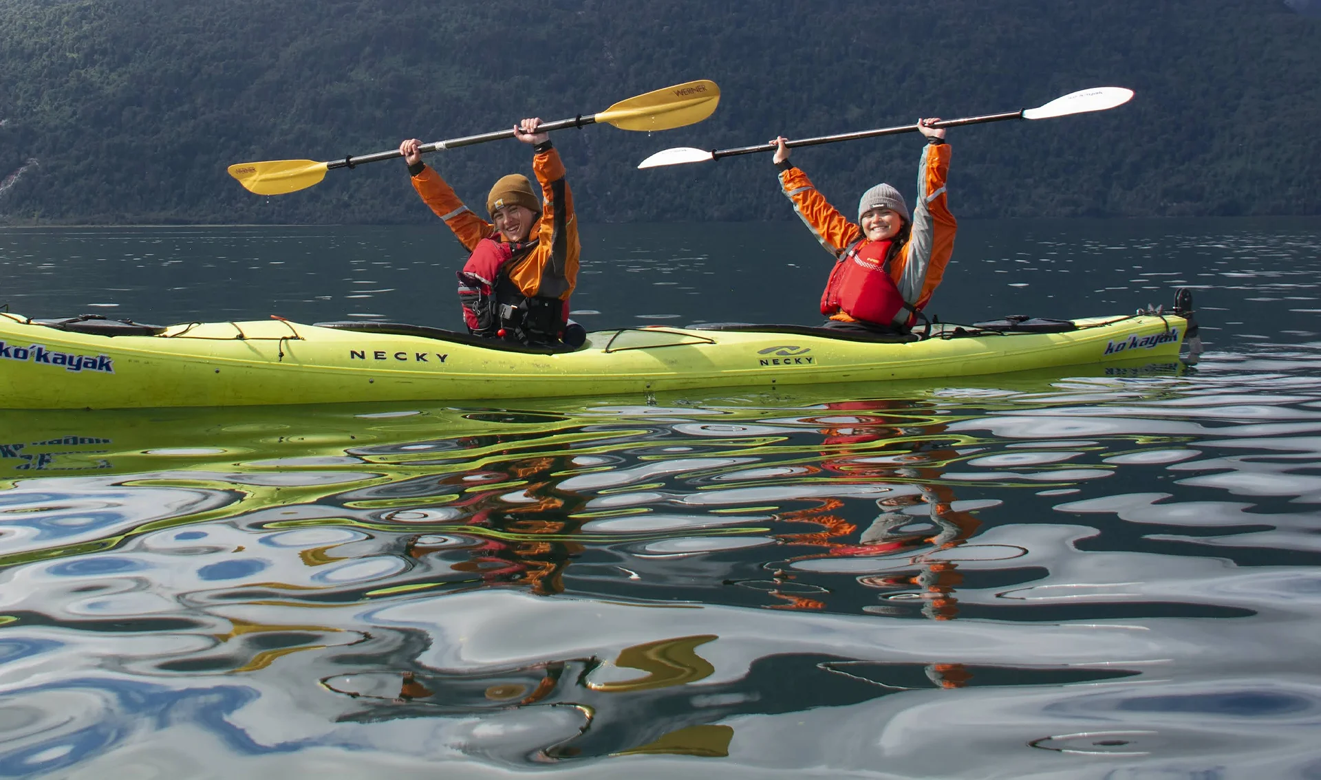Two girls riding in a green kayak
