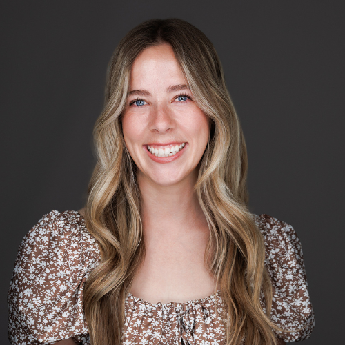 Brooke's headshot features her in a printed blouse and a smile.
