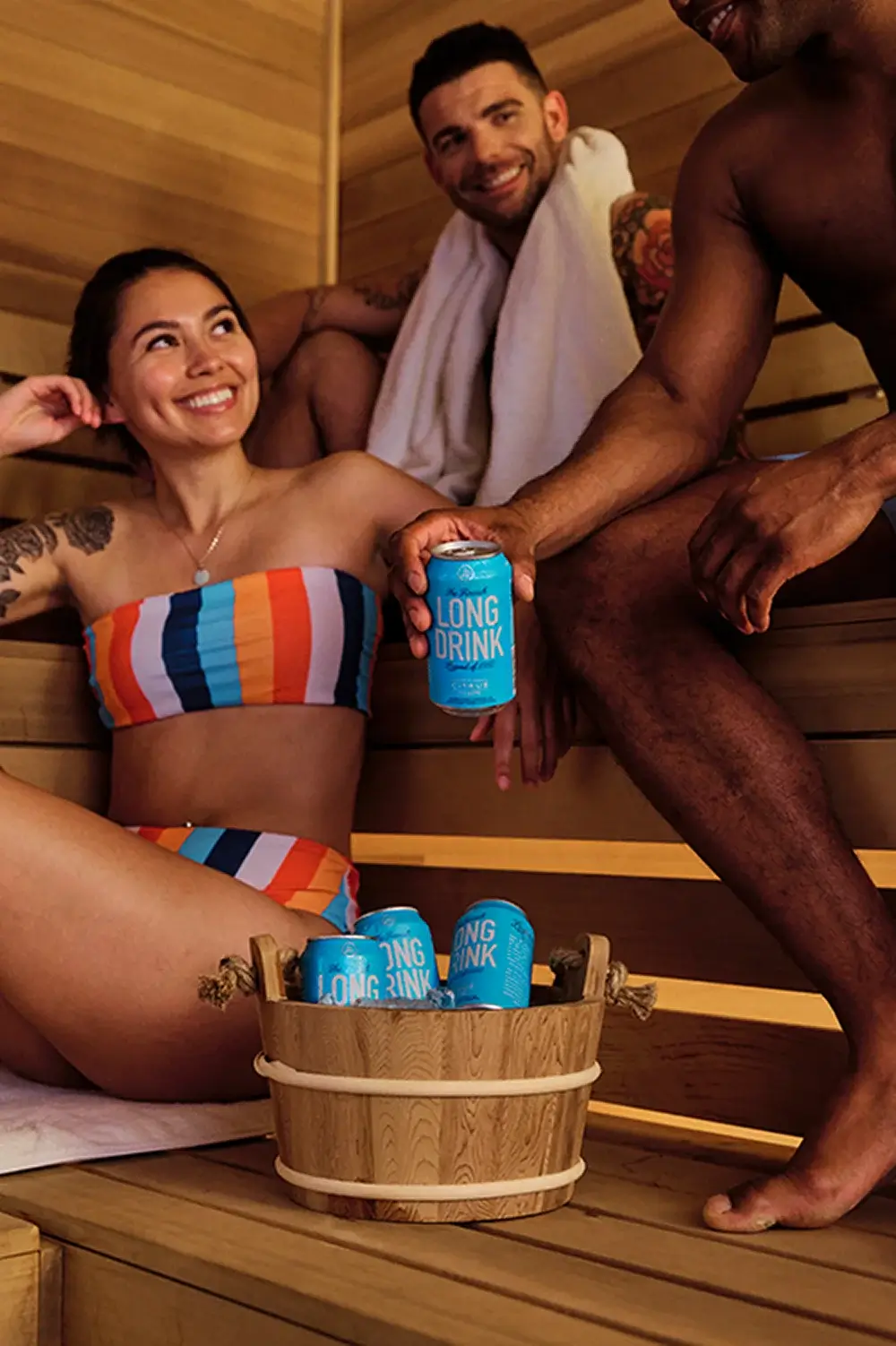 Multiple people smiling in a sauna drinking Long Drink