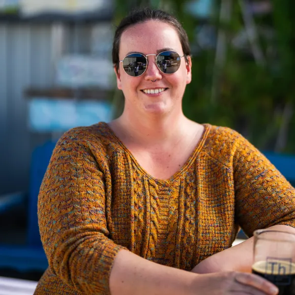 A picture of Kelti outside Theoretically Brewing sipping a beer.