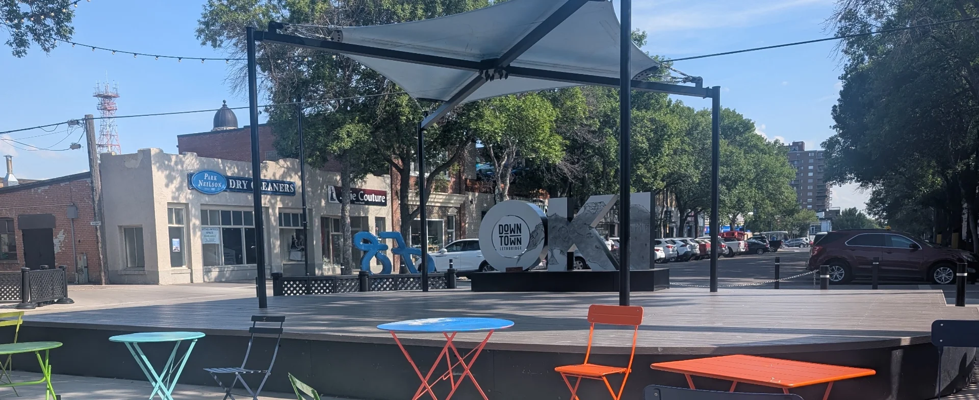 A picture of the Festival Square in downtown Lethbridge featuring the stage and Oki sign.