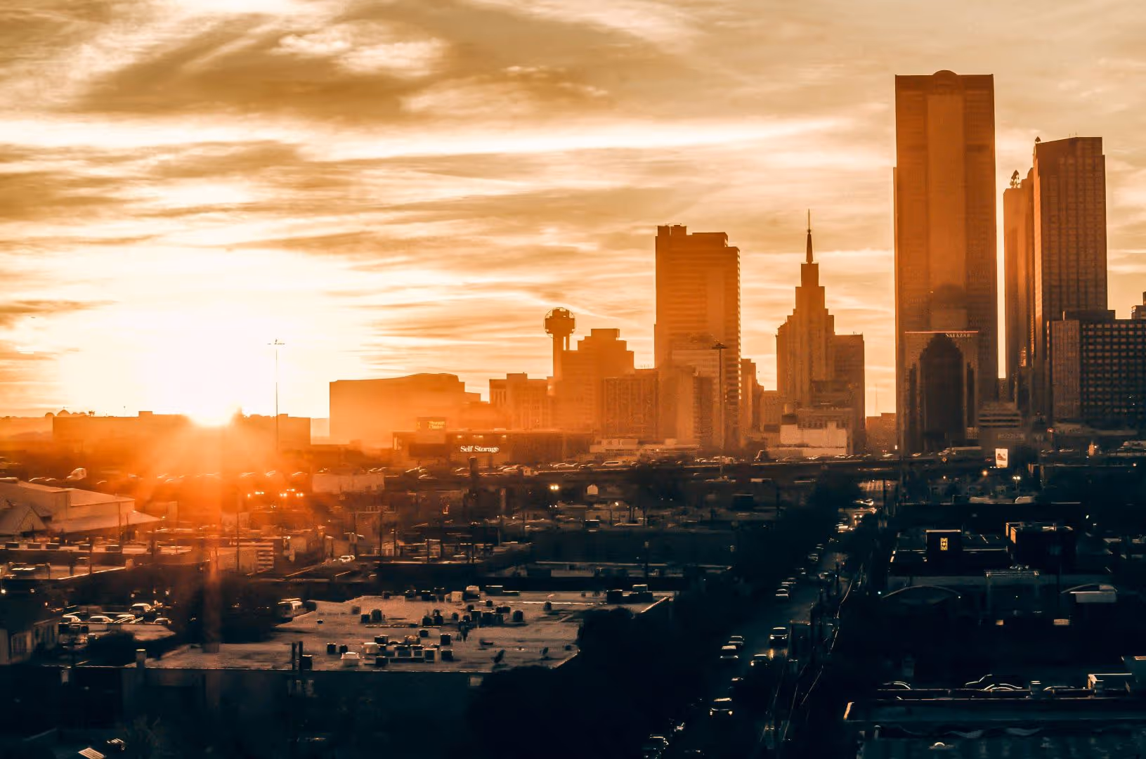 Sunset view of downtown Dallas, Texas with high-rise buildings and warm city lights — representing Sell2Rent’s presence in the Texas residential leaseback market.