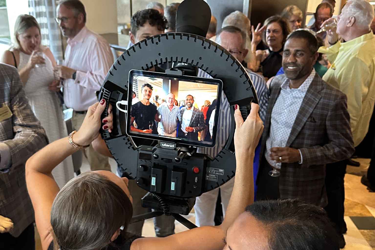 Interactive Roaming Photo Booth in action at a busy Miami conference, capturing attendees with a ring light setup and instant digital sharing.