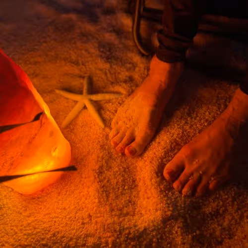 Feet on a bed of salt with a salt stone