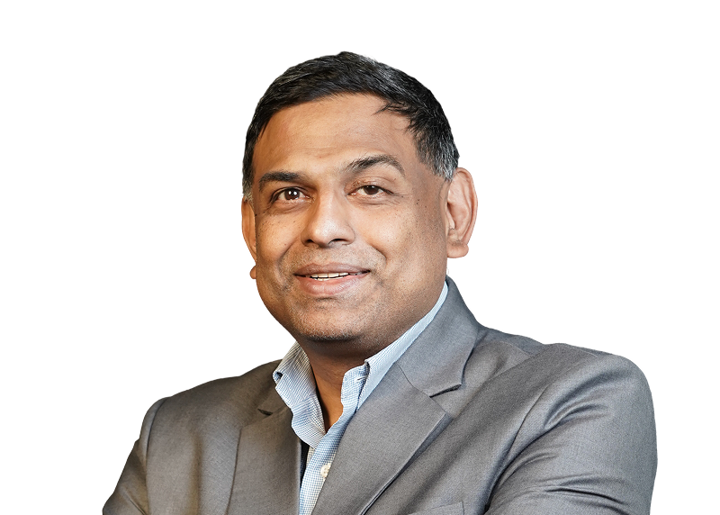 Man in gray suit jacket and blue shirt smiling with arms crossed on a transparent background.
