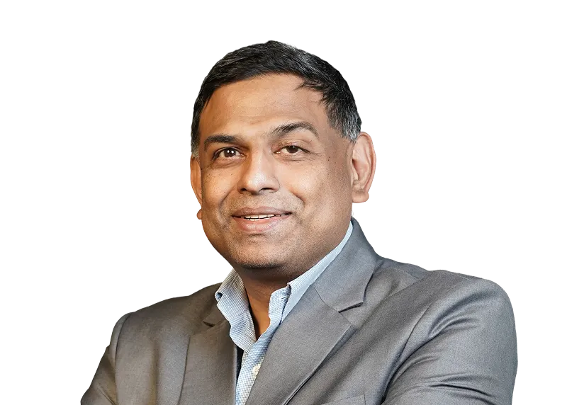 Man in gray suit jacket and blue shirt smiling with arms crossed on a transparent background.