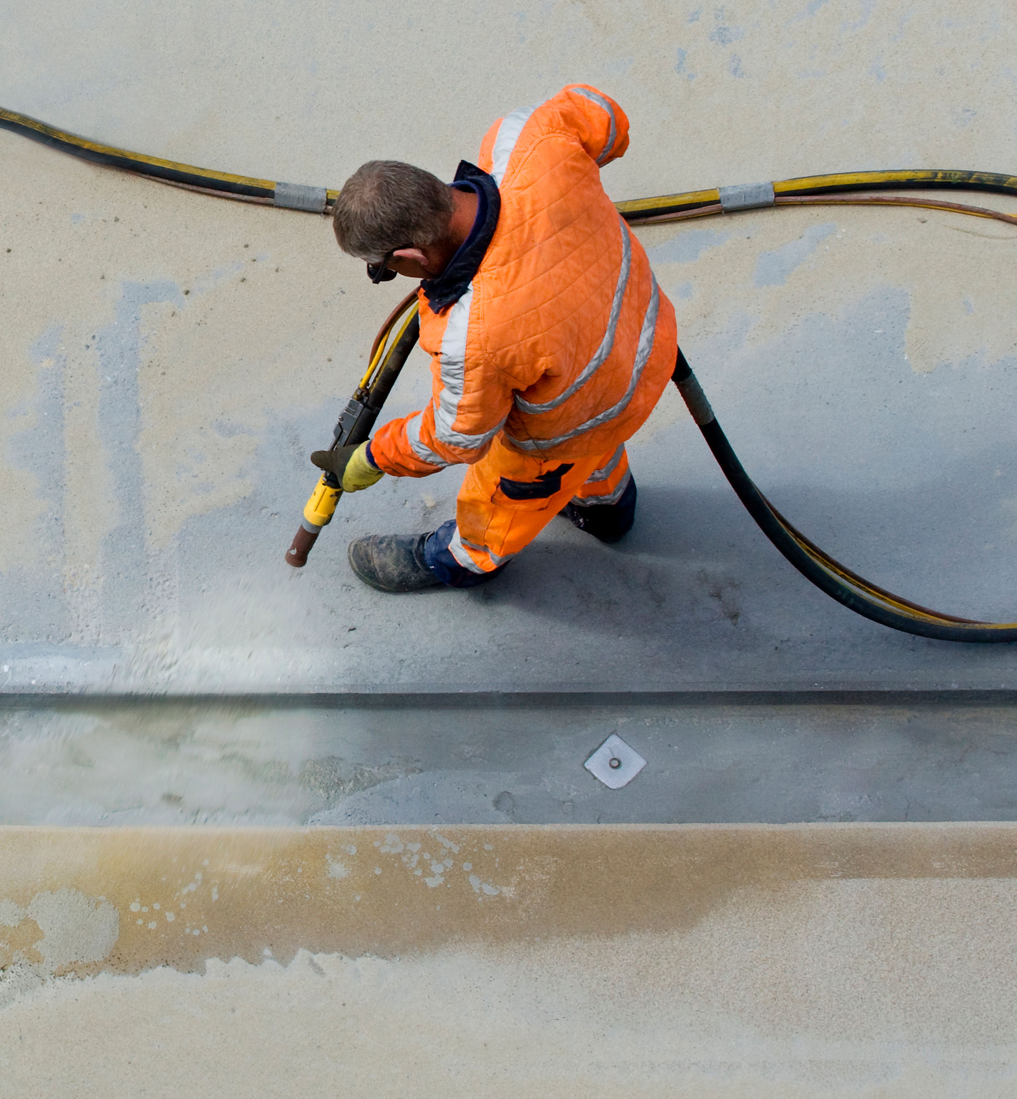 Worker pressure cleaning commercial concrete surface