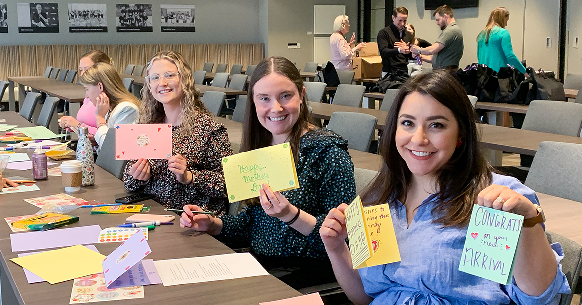 FS employees holding up handmade Mother's Day cards.