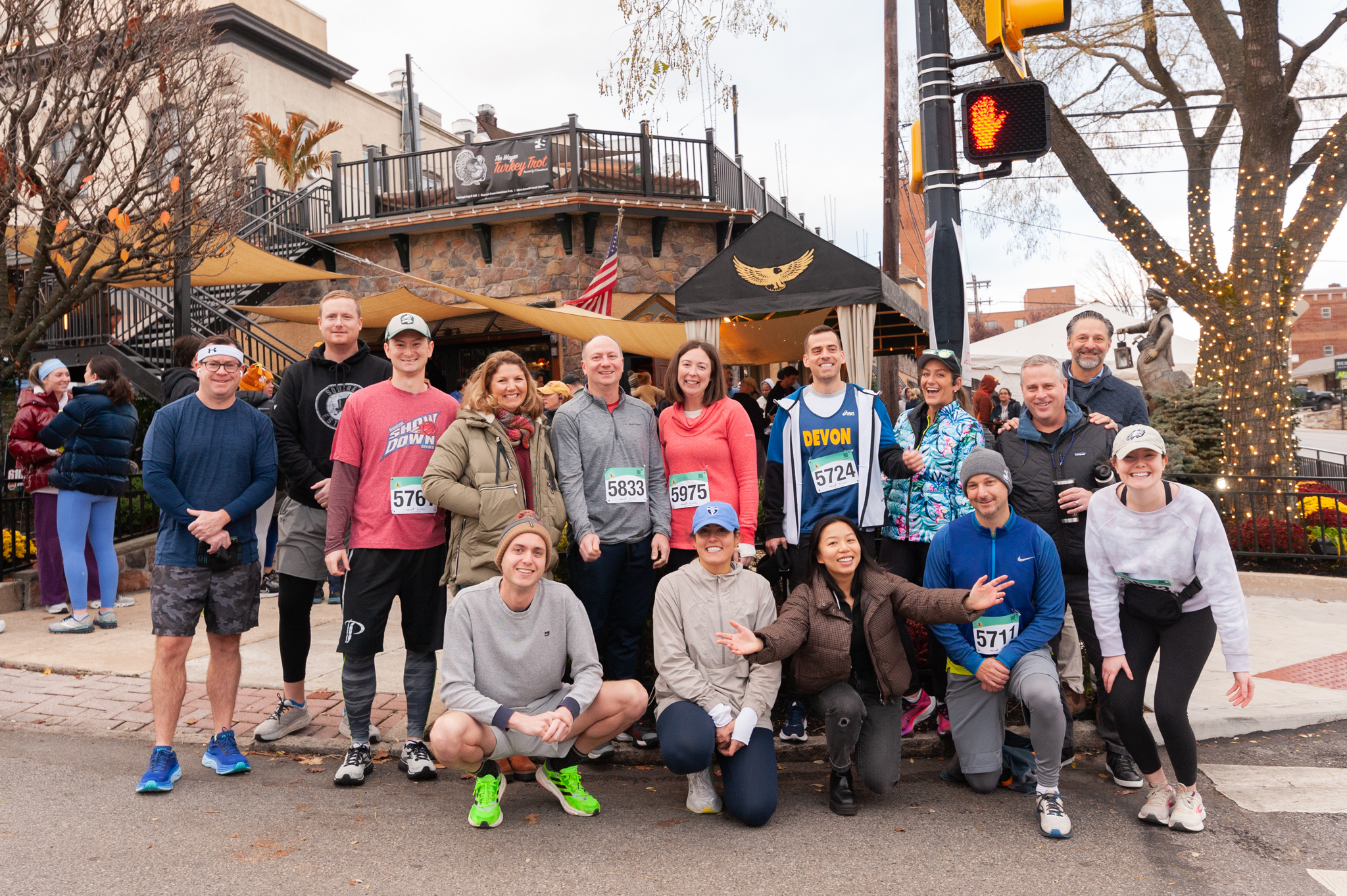 Group photo of 5k participants wearing athletic clothes, some with numbers pinned to their shirts.