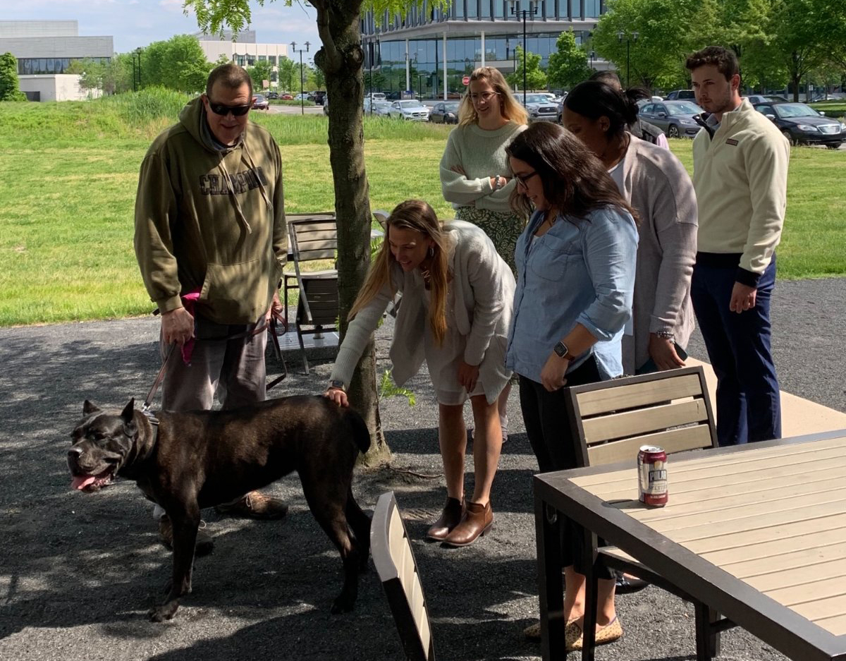 FS employees gathered around a therapy dog outside of the Philadelphia office.