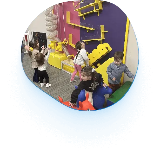 An image of kids playing with colorful interactive puzzles on the wall.