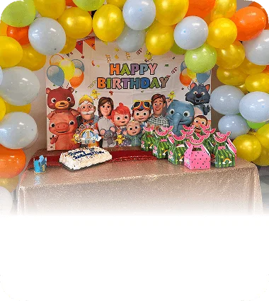 An image of a cartoon-themed birthday party space with balloons and cake