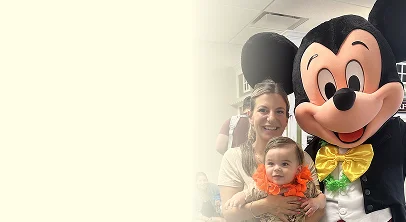 An image of a mother and child posing with Mickey Mouse character at Little Laughs Playtime
