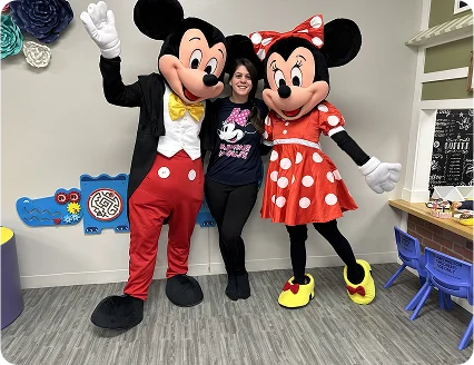 An image of Mickey and Minnie Mouse mascots posing for photos at a kids’ birthday event.
