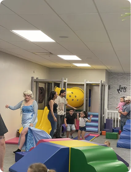 An image of a decorated party room with tables, balloons, and activity setups.