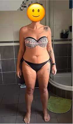 Eine Frau im Bikini mit Smiley-Emoji über dem Gesicht steht in einem Badezimmer.