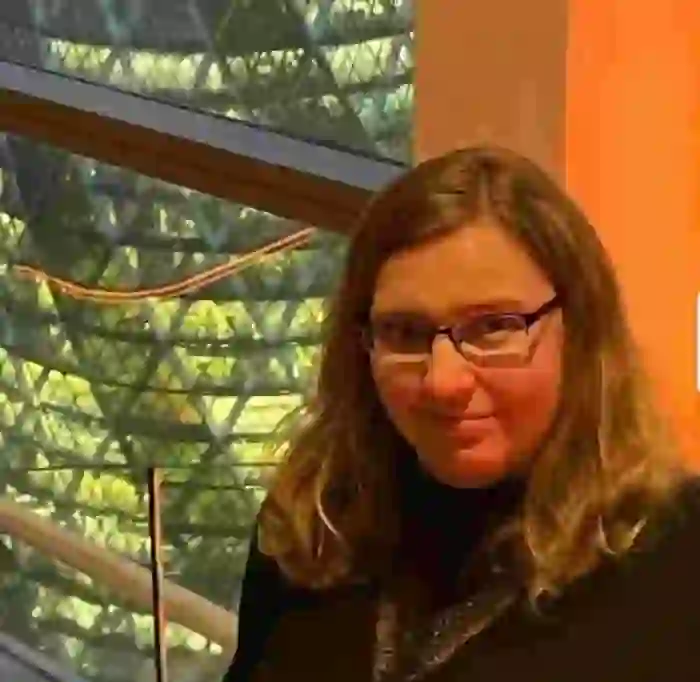 WPF Community - Eine lächelnde Frau mit Brille und langen braunen Haaren.