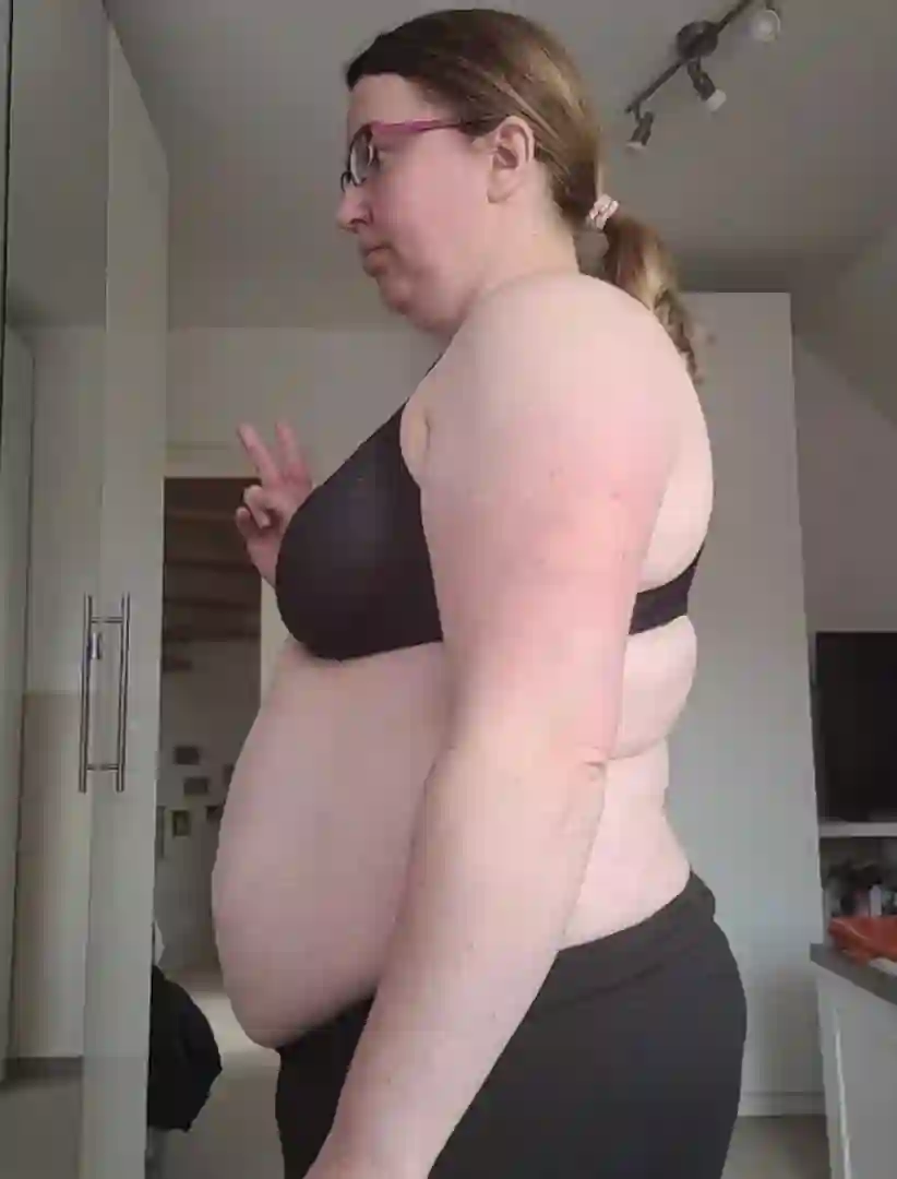 Eine Frau in Sport-BH und Hose zeigt das Friedenszeichen.