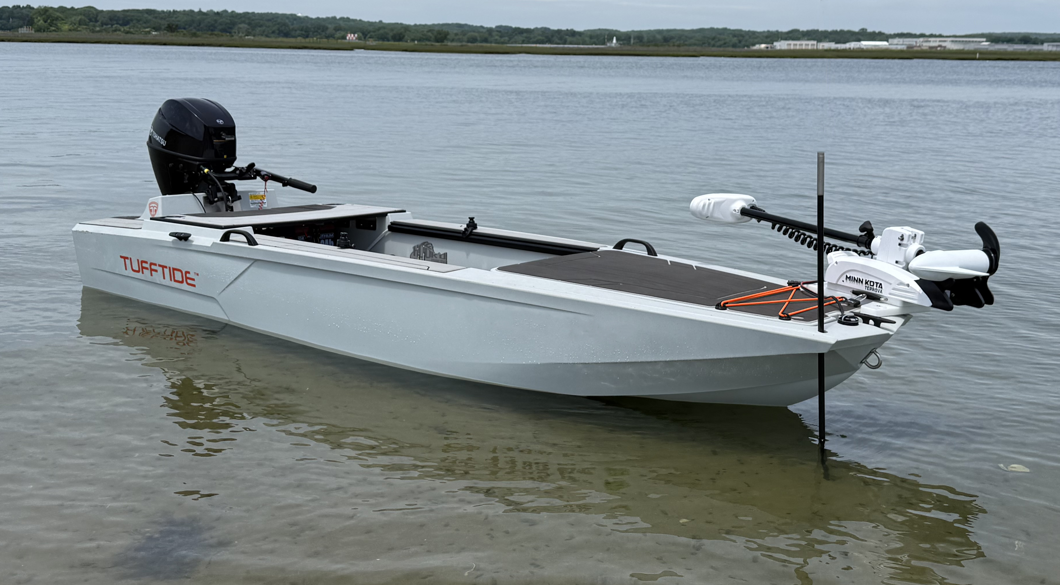 Gray TuffTide boat with outboard motor and a Minn Kota trolling motor floating in shallow water.