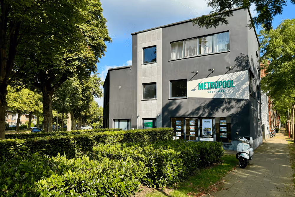 Kantoor van Metropool Vastgoed in donkergrijs gebouw met groene omgeving