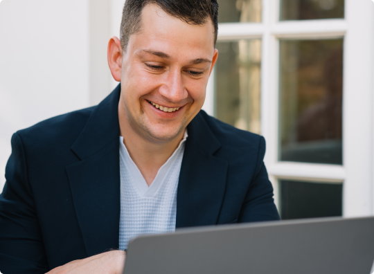 elmos employee smiling at laptop
