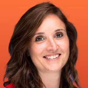 Femme souriante aux cheveux bruns mi-longs sur fond orange.