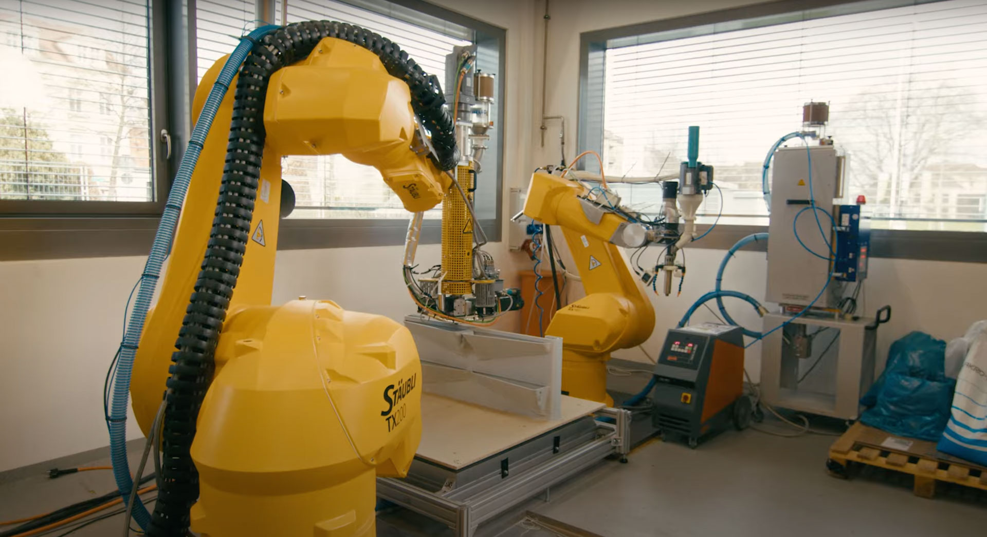 Zwei Industrieroboter beim 3D-Druck begrünbarer Fassadenelemente in einem Forschungslabor.