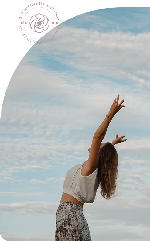 Woman with long hair stretching her arms upward against a partly cloudy sky.